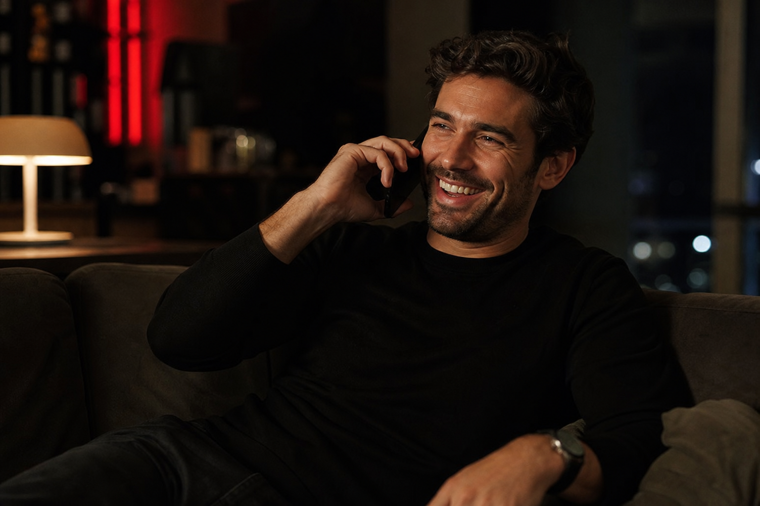 Man smiling on a late-night phone call at home